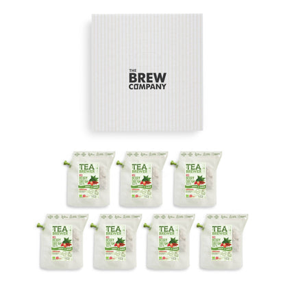 Grüner Tee mit roten Beeren und Apfel in einer Tasse